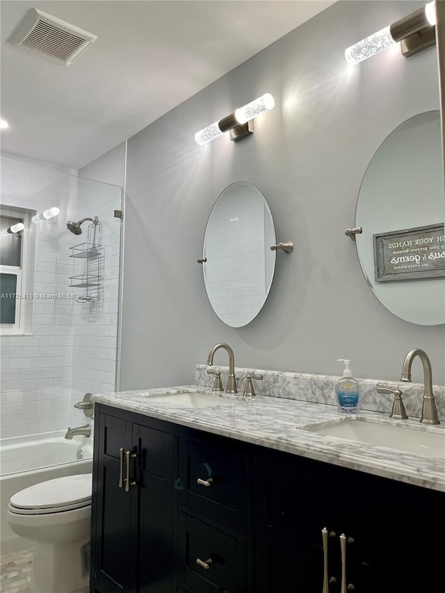 full bathroom with vanity, tiled shower / bath combo, and toilet