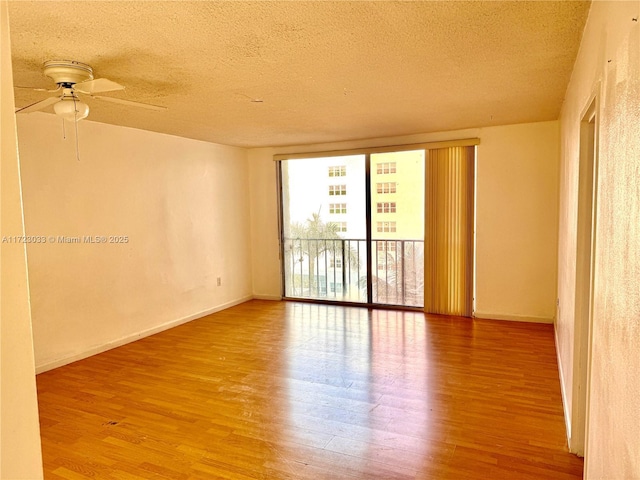 spare room with hardwood / wood-style flooring, a textured ceiling, and ceiling fan