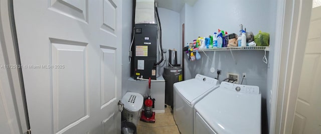 washroom featuring electric water heater, heating unit, independent washer and dryer, and light tile patterned floors