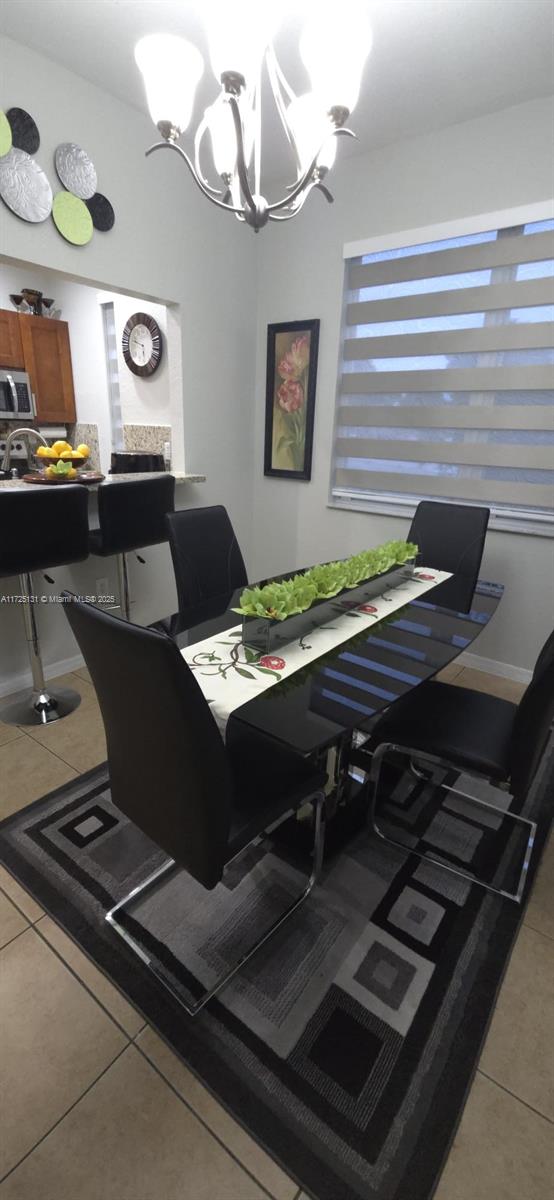 tiled dining area featuring a chandelier