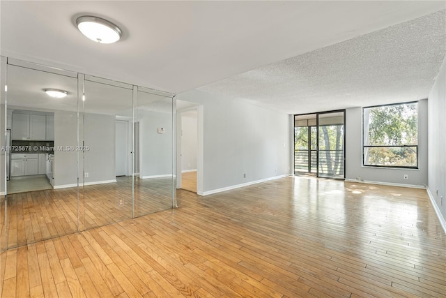 empty room featuring a textured ceiling and light hardwood / wood-style floors