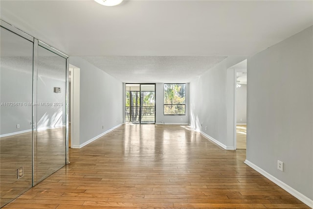 empty room featuring a textured ceiling, ceiling fan, and light hardwood / wood-style flooring