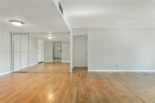 interior space featuring wood-type flooring and a textured ceiling