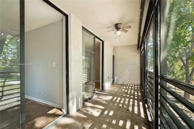 unfurnished sunroom with ceiling fan