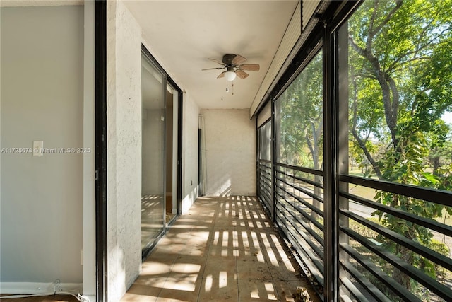 unfurnished sunroom featuring ceiling fan