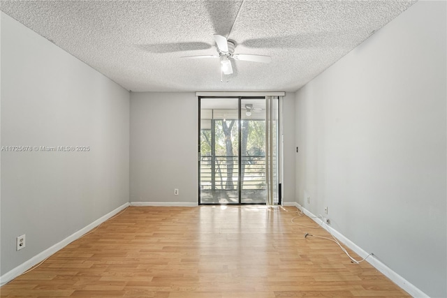 empty room featuring light hardwood / wood-style floors, a textured ceiling, ceiling fan, and floor to ceiling windows