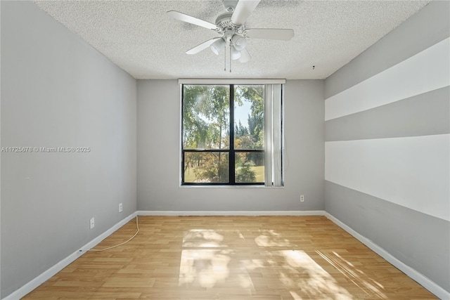 spare room with a textured ceiling, ceiling fan, and light hardwood / wood-style floors