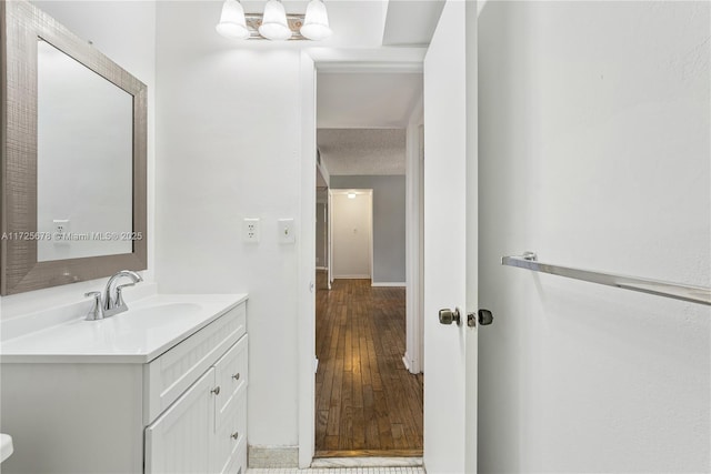 bathroom with a textured ceiling, vanity, and hardwood / wood-style flooring