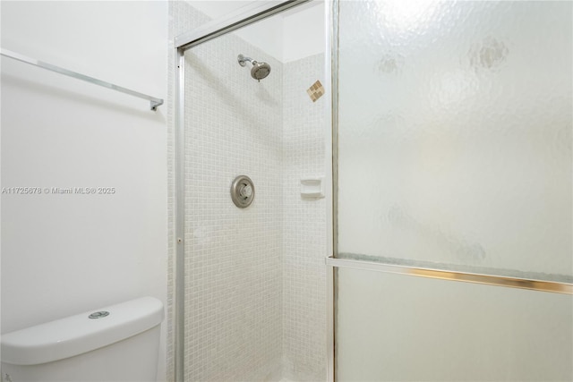 bathroom with toilet and an enclosed shower