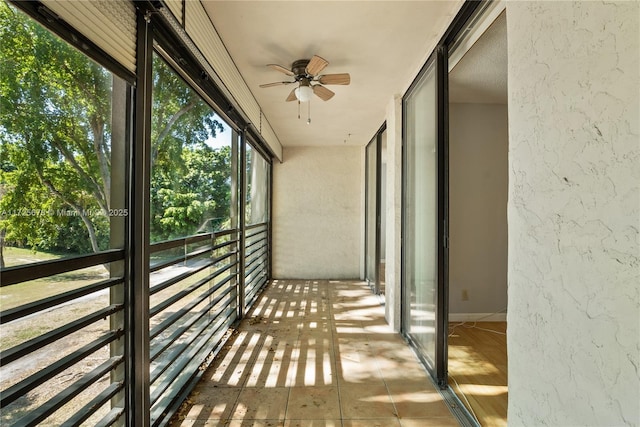 unfurnished sunroom with ceiling fan