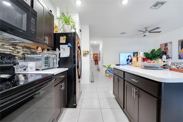 kitchen with visible vents, light countertops, light tile patterned floors, decorative backsplash, and black appliances