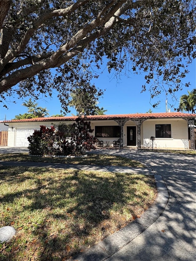 ranch-style house featuring a garage and a front lawn