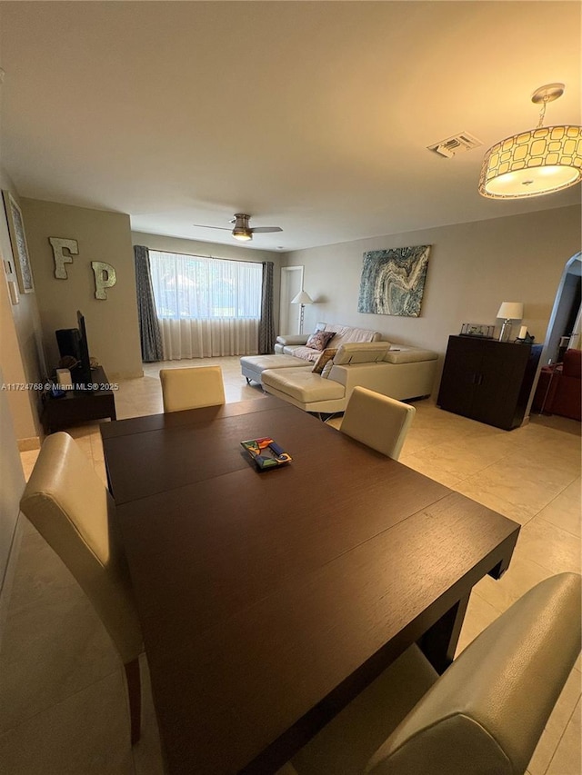 tiled dining area with ceiling fan