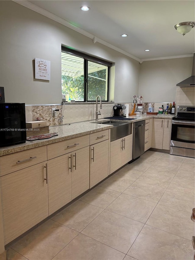 kitchen featuring stainless steel appliances, light stone countertops, crown molding, and sink