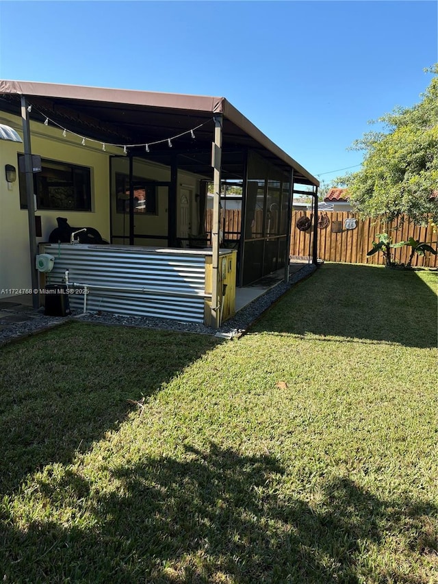 back of house featuring a lawn and a sunroom