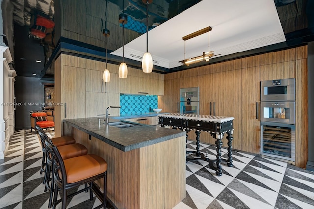 kitchen featuring wooden walls, backsplash, hanging light fixtures, oven, and sink