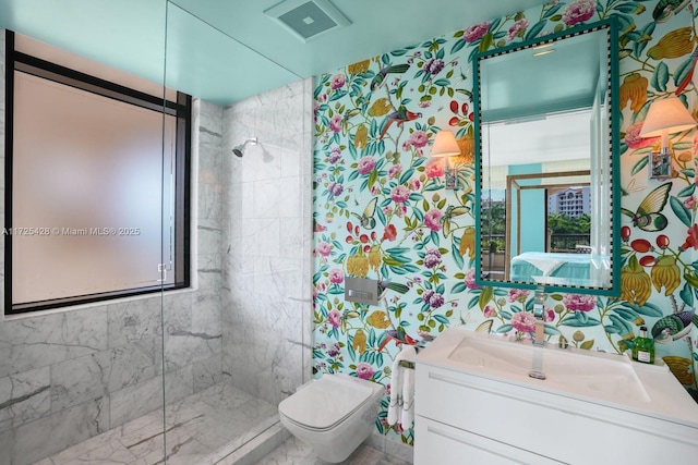 bathroom featuring a tile shower, vanity, and toilet