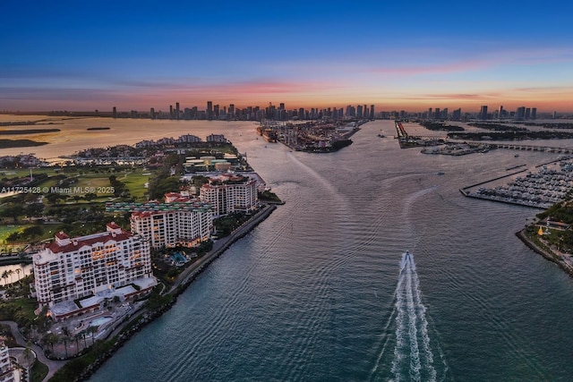 aerial view at dusk with a city view and a water view