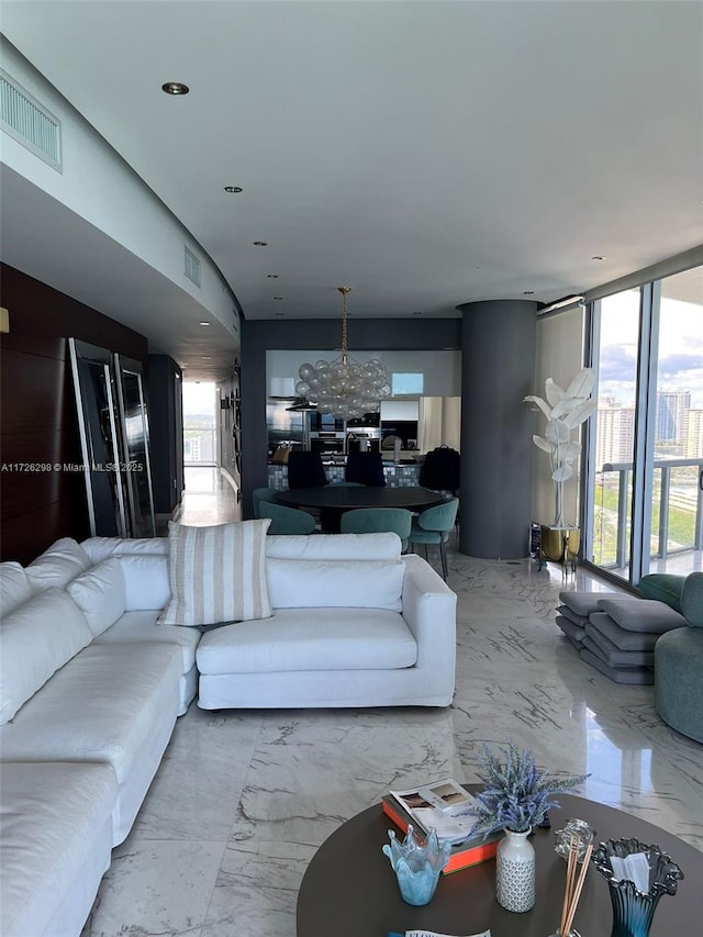 living room with an inviting chandelier, plenty of natural light, and expansive windows