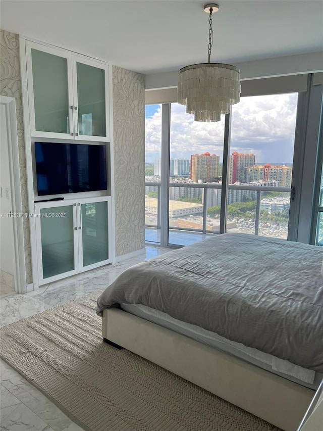 bedroom featuring access to outside and an inviting chandelier