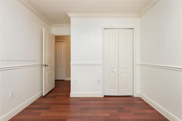 unfurnished bedroom featuring dark wood-type flooring, ornamental molding, and a closet