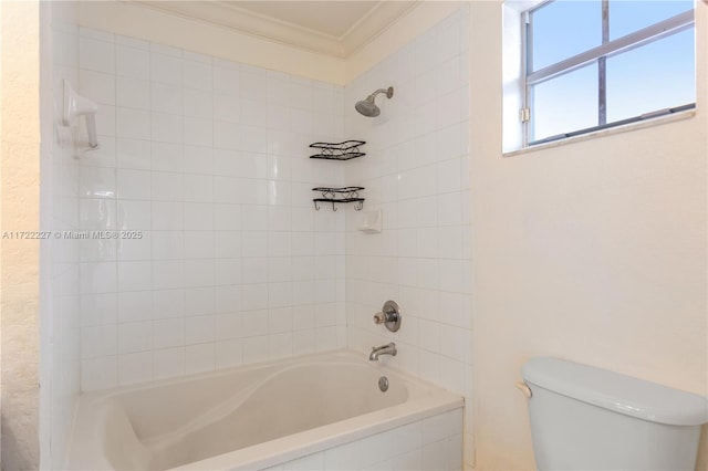 bathroom featuring toilet, tiled shower / bath combo, and ornamental molding