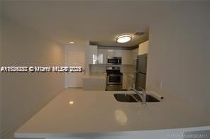 kitchen with sink, stainless steel appliances, kitchen peninsula, and white cabinets