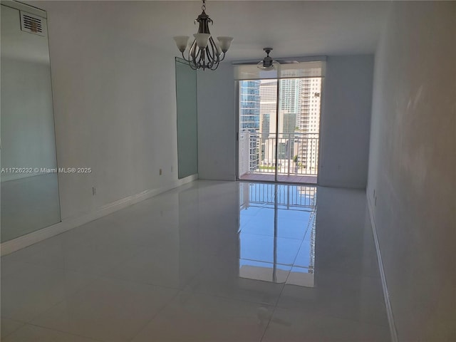 tiled empty room with an inviting chandelier