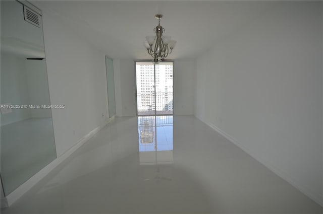 tiled spare room with an inviting chandelier and floor to ceiling windows