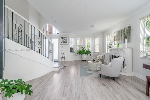 living room with crown molding and light hardwood / wood-style flooring