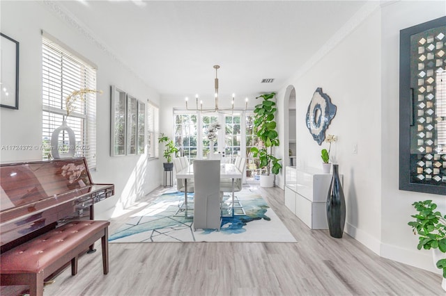 miscellaneous room with built in shelves, light hardwood / wood-style floors, crown molding, and a chandelier