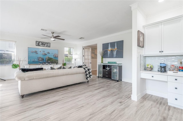 living room with ceiling fan, light hardwood / wood-style floors, and ornamental molding