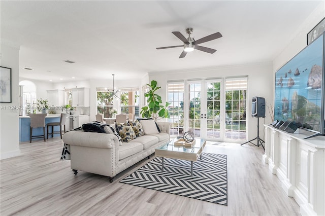 living room featuring ornamental molding, french doors, ceiling fan, and light hardwood / wood-style floors