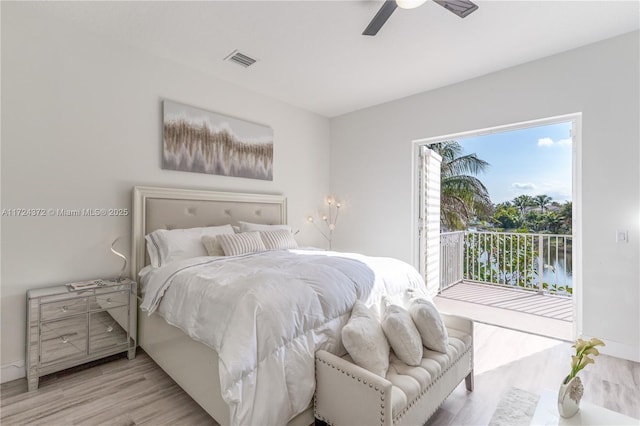 bedroom with a water view, ceiling fan, light wood-type flooring, and access to outside