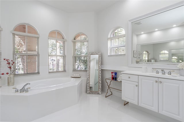 bathroom featuring tiled bath, tile patterned floors, and vanity