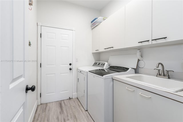 laundry room with separate washer and dryer, light hardwood / wood-style floors, cabinets, and sink