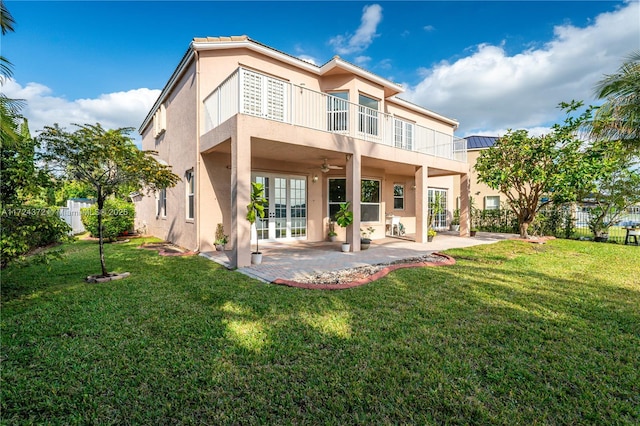 back of property featuring a balcony, a patio, a lawn, french doors, and ceiling fan