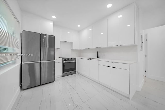 kitchen with stainless steel appliances, white cabinets, and sink