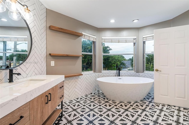 bathroom featuring a bathtub, vanity, and tile patterned flooring