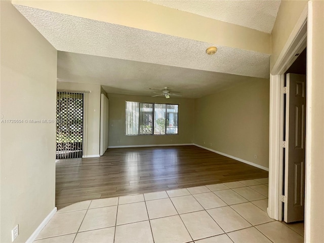 unfurnished room featuring ceiling fan, a textured ceiling, and light tile patterned floors