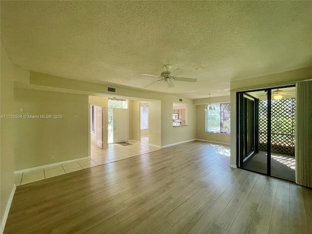 unfurnished room featuring a textured ceiling, ceiling fan, and light hardwood / wood-style floors