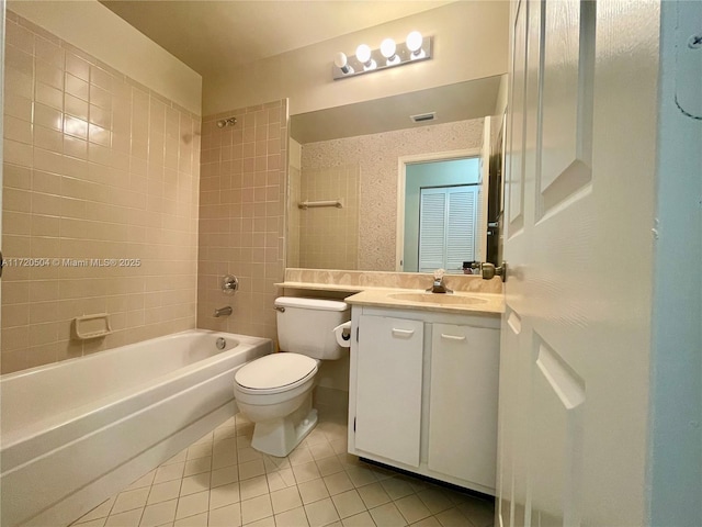 full bathroom featuring toilet, tiled shower / bath combo, tile patterned flooring, and vanity