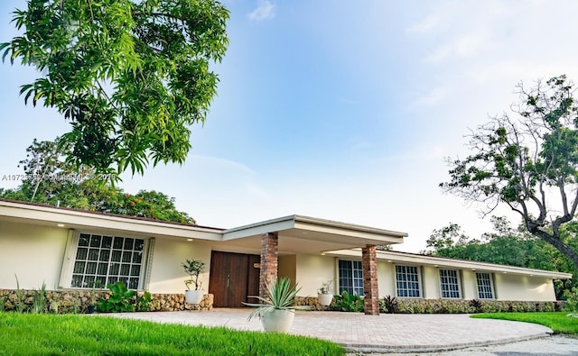 view of front facade featuring stone siding and stucco siding