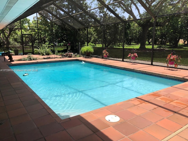 pool featuring a patio and glass enclosure