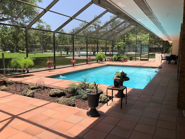 outdoor pool with a lanai, a patio area, and a yard