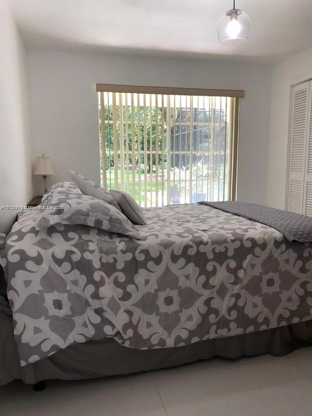 bedroom featuring multiple windows, a closet, and tile patterned floors