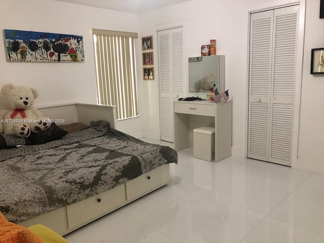 bedroom featuring two closets and tile patterned floors