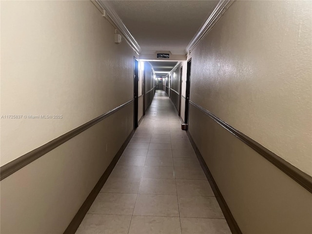 hallway featuring light tile patterned floors and crown molding