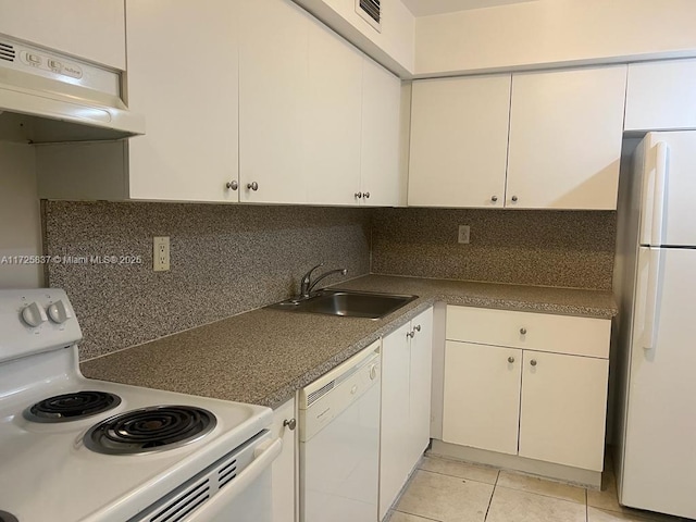 kitchen featuring sink, white appliances, light tile patterned floors, and white cabinets