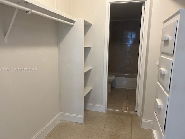 walk in closet with light tile patterned flooring